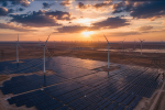 Wind turbines and a solar farm feeding the grid at sunset