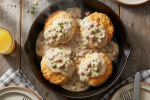Skillet of biscuits and gravy on a rustic wooden table
